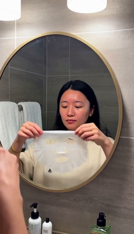 Preview of Sheet mask pressed onto the face, both hands